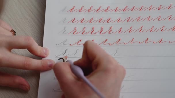 Bir kız kaligrafi defterini güzel sembollerle dolduruyor. - Video, Çekim