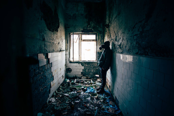 human wearing a gas mask in a ruined building - Foto, Bild