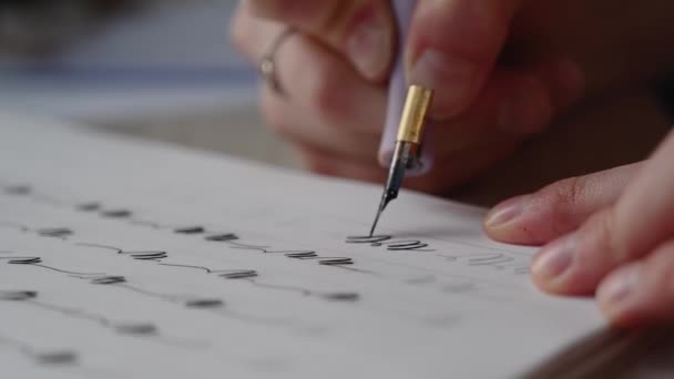 dziewczyna wypełnia notatnik kaligrafii pięknymi symbolami - Materiał filmowy, wideo