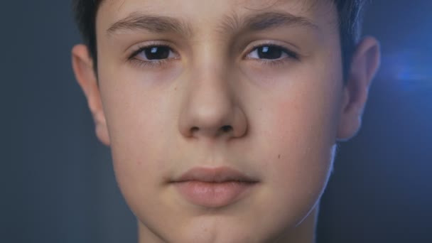 Nahaufnahme Porträt eines süßen Jungen im Alter von 10 Jahren, der abends zu Hause in die Kamera schaut - Filmmaterial, Video