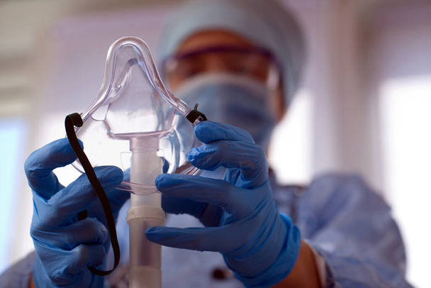 γιατρός σε προστατευτικό εξοπλισμό τεθεί σε οξυγόνο διάγνωση ασθενή μάσκα του coronavirus - Φωτογραφία, εικόνα