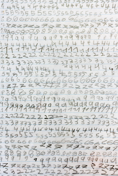 Tarea de un niño de escuela primaria que repite los números con una carta para niños. - Foto, imagen