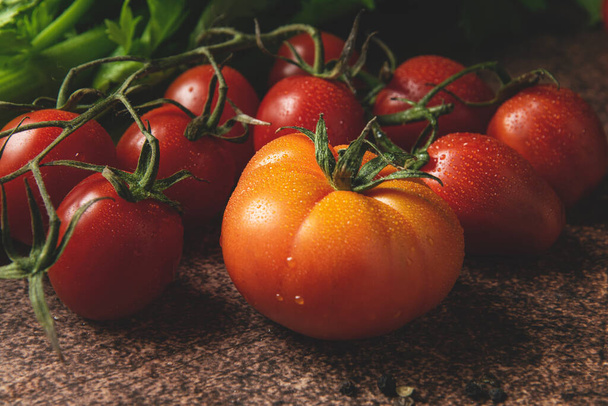 Fresh ripe organic tomatoes on dark rustic background - Photo, Image