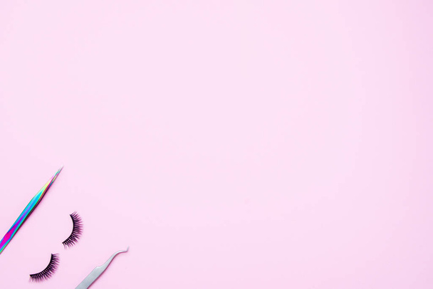 Set for eyelash extension on a pink background. Concept beauty beauty. False eyelashes and tweezers. - Photo, Image
