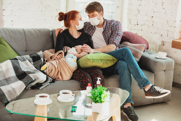 Caucasian family in protective masks and gloves isolated at home with coronavirus symptoms, treatment - 写真・画像