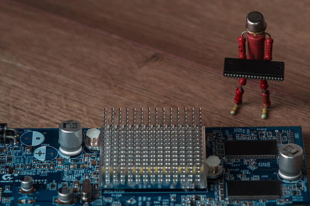 маленька людська фігура ручної роботи з резисторів допомагає зібрати сучасну міцну вбудовану комп'ютерну дошку
 - Фото, зображення