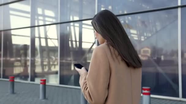 In the city, a businesswoman answers the phone, send messages and smiles for the beautiful job news. Concept: technology, telephony, business trips, business. - Materiał filmowy, wideo