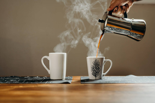 Tasses à café sur table en bois avec nacelle Moka dans le salon. Arrière-plan avec espace texte libre
. - Photo, image