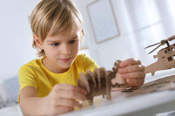 Little boy making carton toys at table indoors. Creative hobby - Φωτογραφία, εικόνα