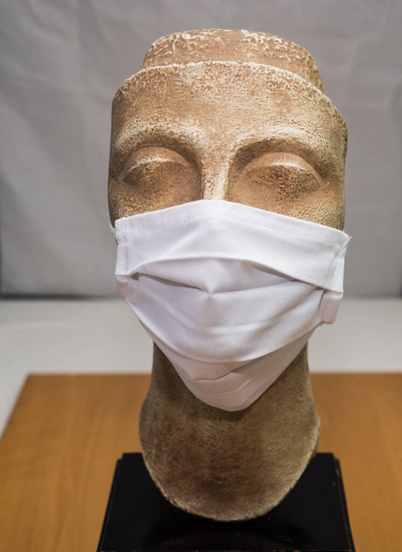 bust with coronavirus mask, ancient Greek bust waring a coronavirus mask at home - Photo, Image