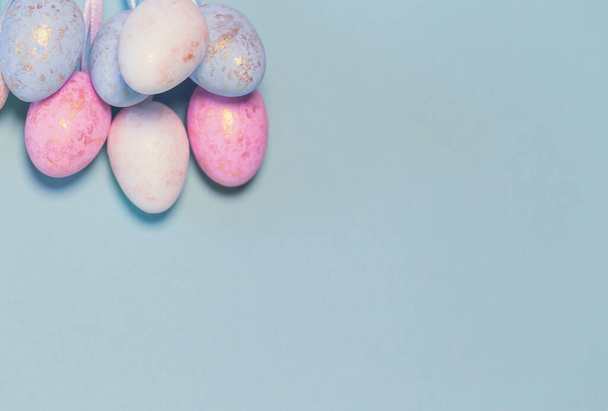 Decorative easter eggs on colorful pastel background. Holiday backdrop for seasonal cards, blogs and web design. Minimal style - Фото, изображение