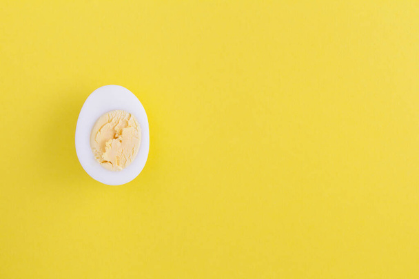Half boiled chicken egg on the yellow  background. Top view. Copy space. - Photo, Image