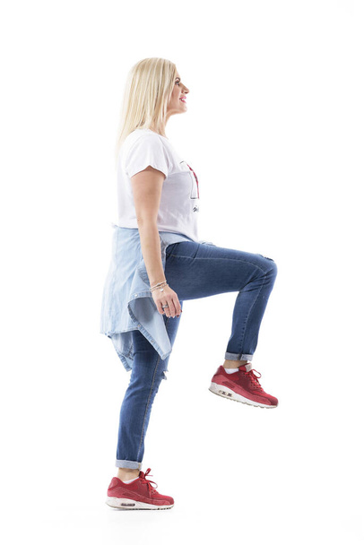 Success concept. Happy middle age casual woman walking up climbing on invisible stairs looking up. Full body length isolated on white background. - Foto, Imagem