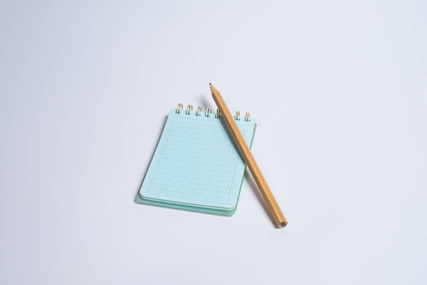 Top view of open spiral blank notebook with wood pencil on white desk background - Foto, Imagem
