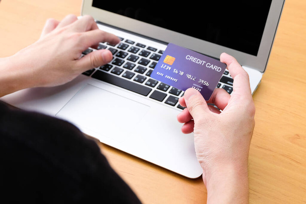 Men hand holding credit card and type payment information on keyboard for order online shopping. Internet technology and Digital market place E-Commerce lifestyle concept, Purchase transaction. - Photo, Image