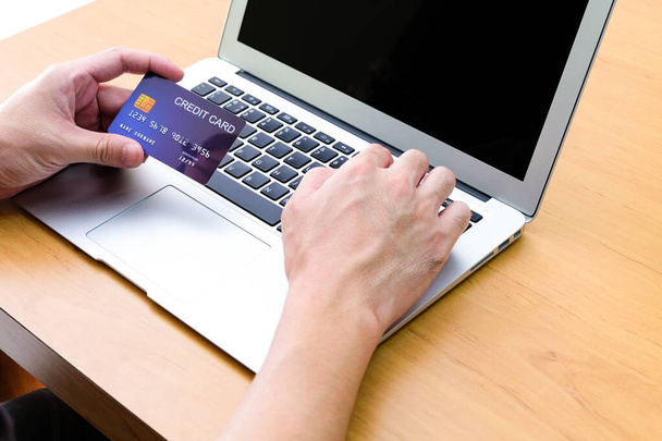 男性はオンラインショッピングを注文するために、クレジットカードを保持し、キーボードの支払い情報を入力します。インターネット技術とデジタル市場の場所｜電子商取引のライフスタイルの概念,購入取引. - 写真・画像