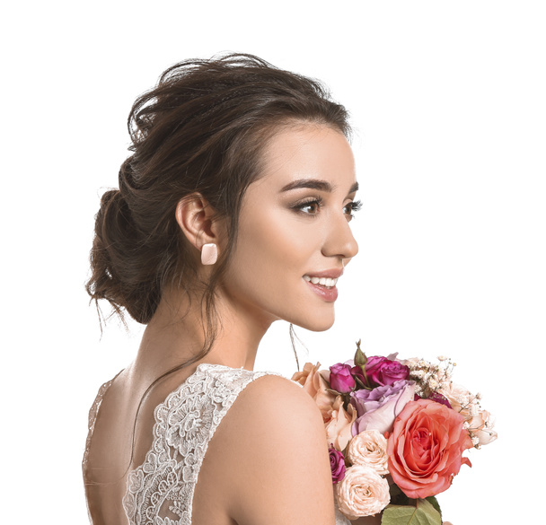 Young bride with beautiful hairdo and flowers on white background - Photo, Image