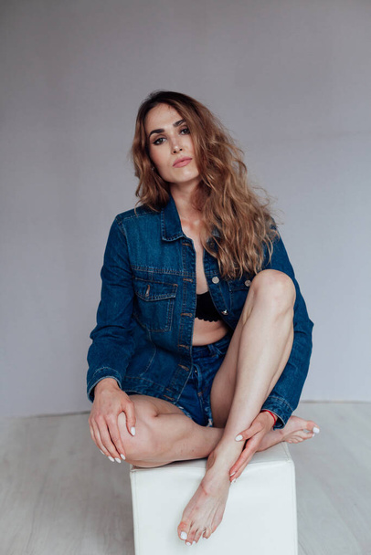 Portrait of a beautiful woman in denim shorts and lingerie - Photo, Image