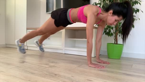 Νεαρή Fitness Γυναίκα σε Sportswear κάνει δυναμική σανίδα Άσκηση στο σπίτι ή στο στούντιο - Πλάνα, βίντεο