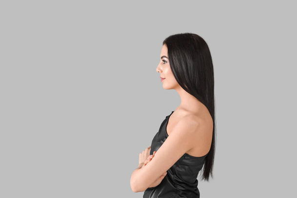 Young woman with beautiful healthy hair on grey background - Zdjęcie, obraz