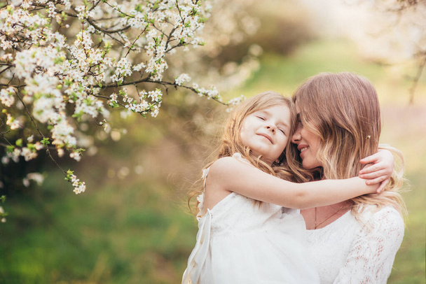 Beautiful Mother And her little daughter outdoors. Nature. Beauty Mum and her Child playing in Park together. Outdoor Portrait of happy family. Happy Mother's Day Joy. Mom and Baby. - Foto, imagen