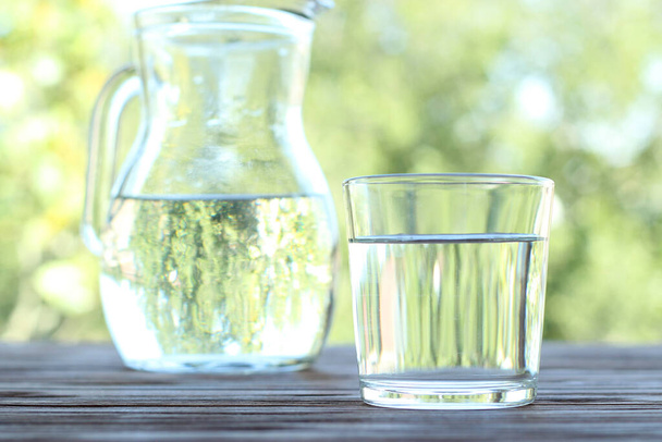 καθαρό νερό σε ένα ποτήρι σε ένα τραπέζι για τη φύση. Καθαρό νερό. - Φωτογραφία, εικόνα