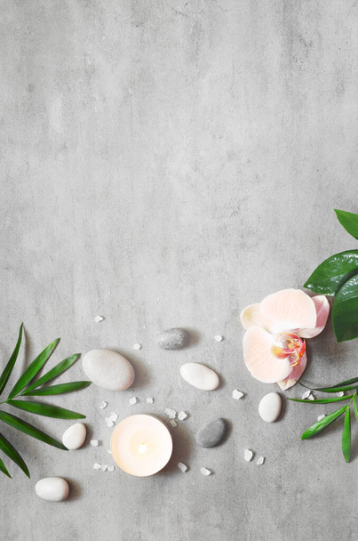 Spa concept on stone background, palm leaves, flower, candle and zen, grey stones, top view, copy space - Photo, Image