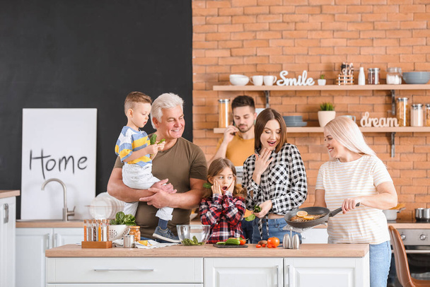 Велика сім'я готує разом на кухні
 - Фото, зображення