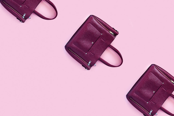 Beautiful leather purple handbags on a pink paper background  in zine style. Top view, flat lay, copy space concept. - Foto, Imagem