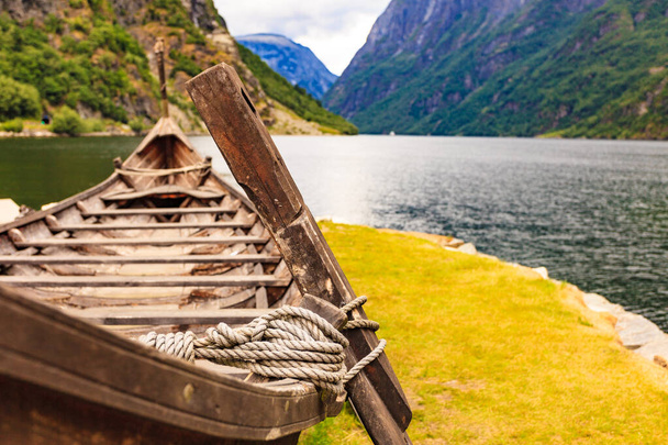 Old wooden viking boat on fjord shore. Mountains and Sognefjord. Tourism and traveling concept - Фото, зображення