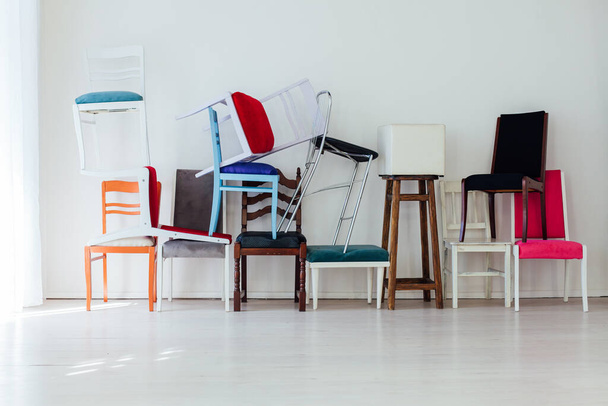 πολλές διαφορετικές καρέκλες σε σύγχυση στο εσωτερικό ενός άδειου λευκού δωματίου - Φωτογραφία, εικόνα