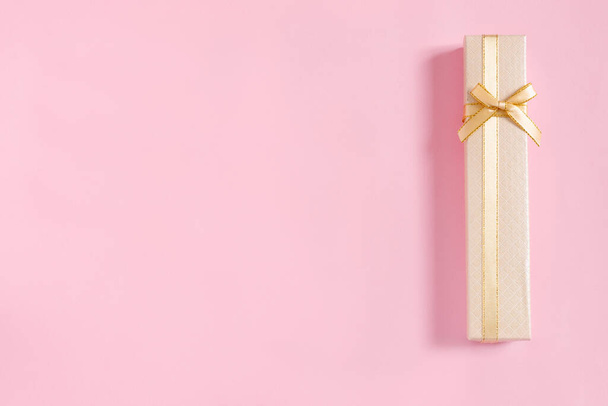 Golden gift boxes with bow for congratulations on pink paper background. Top view, flat lay, copy space concept. - Fotoğraf, Görsel