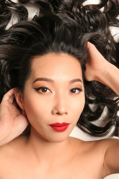 Joven mujer asiática con hermoso cabello sobre fondo blanco
 - Foto, imagen