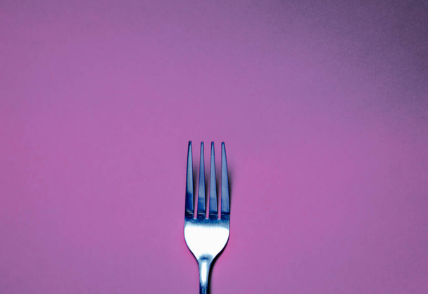 Fork on violet background. Backgrounds for food - Фото, зображення