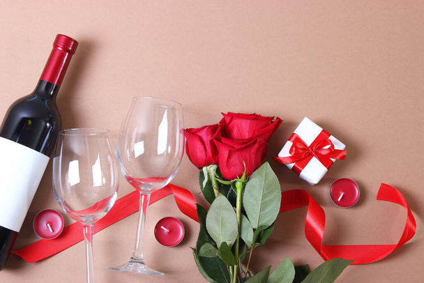 赤ワイン、ハート、赤いバラとギフトの色の背景トップビュー. - 写真・画像