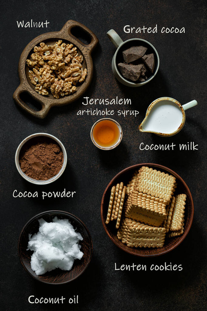 Ingredienti per la cottura di salumi vegetariani al cioccolato con nomi di prodotto su sfondo scuro. Posa piatta
 - Foto, immagini