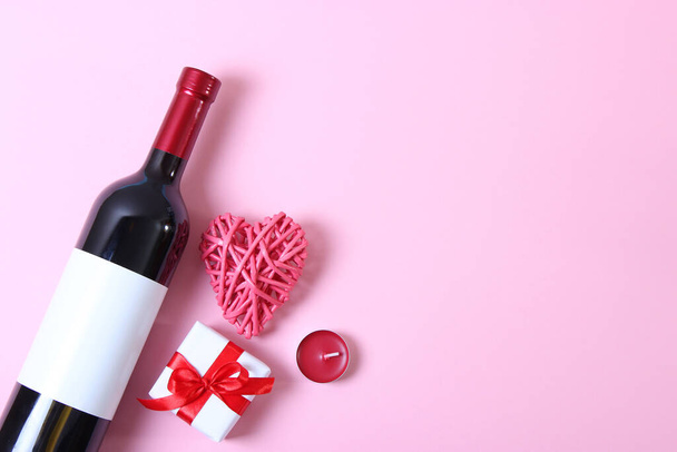 Rotwein, Herzen, rote Rosen und Geschenke auf farbigem Hintergrund von oben. - Foto, Bild