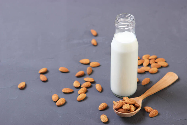 Almond milk and almonds on the table. Vegetable milk. Vegetarian milk. - Фото, зображення