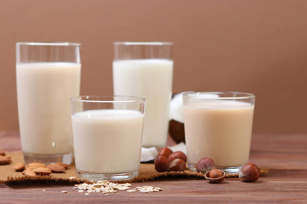 Différents types de lait végétal sur la table. Noix de coco, flocons d'avoine, noisettes, lait d'amande. Lait végétarien
. - Photo, image