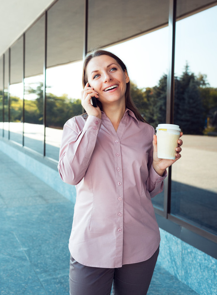 νεαρός επιχειρηματίας με κινητό τηλέφωνο και καφέ ενώ στέκεται Αγά - Φωτογραφία, εικόνα
