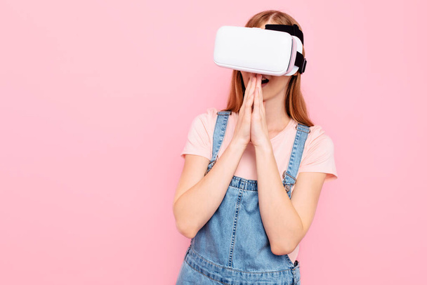 Young beautiful stylish woman with virtual reality glasses, on an isolated pink background - Foto, Imagem