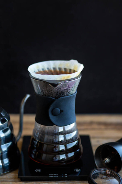 Мелена кава в воронці. Ритуал приготування кави. Виготовлення кави в домашніх умовах. Фільтрована або переповнена це метод, який передбачає заливання води на обсмажену мелену кавову зерна, що містяться в фільтрі
 - Фото, зображення