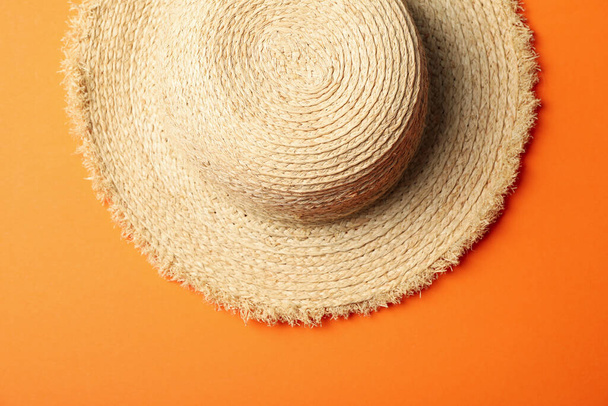 Straw hat on orange background, top view - Foto, afbeelding