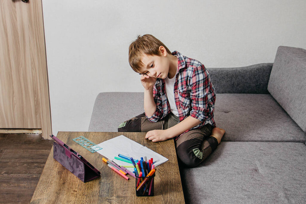 Chłopiec siedzi w domu w izolacji i uczy się online - Zdjęcie, obraz