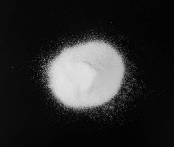 Montón de polvo blanco de bicarbonato de sodio, arcilla o bentonita sobre fondo negro. Productos químicos en polvo como calcio, yeso o yeso Vista superior - Foto, Imagen