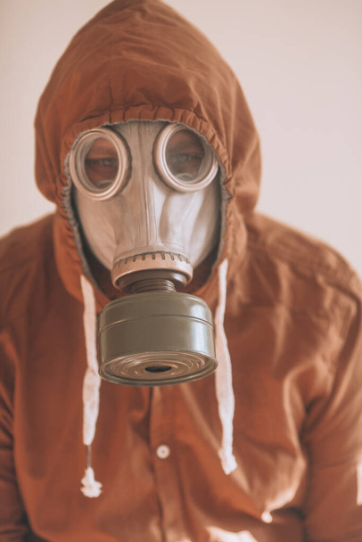 Retrato numa máscara de gás. Homem com uma máscara protetora de gás e roupas castanhas
 - Foto, Imagem