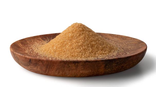 Pile of brown sugar on wooden plate isolated on white background. Raw unrefined cane sugar heap side view - Photo, Image