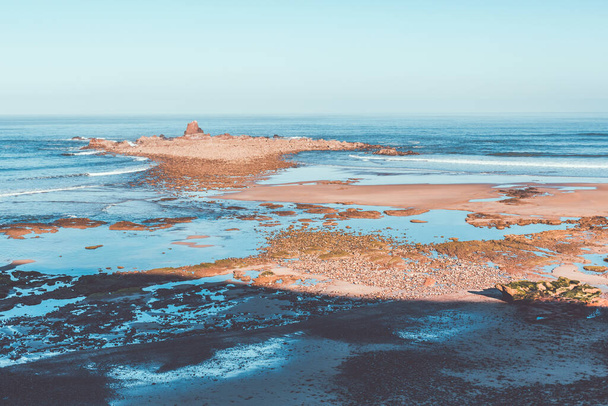 Vista panorâmica do Oceano Atlântico. Praia rochosa na maré baixa. Acalmar a paisagem marinha. Céu azul claro
 - Foto, Imagem