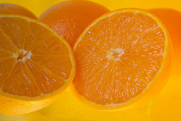 黄色の背景に孤立した新鮮なオレンジ果実。黄色の背景に新鮮なオレンジの皮のクローズアップ。バイオ・健康食品. - 写真・画像