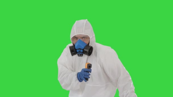 Virologist checks temperature with an infrared thermometer James Bond parody on a Green Screen, Chroma Key. - Felvétel, videó